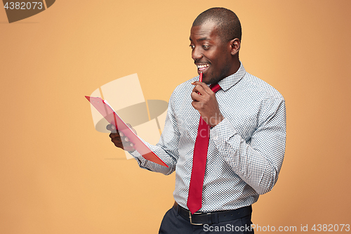 Image of Attractive standing Afro-American businessman writing notes