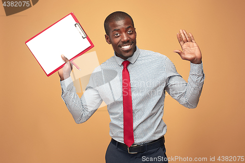 Image of Attractive standing Afro-American businessman writing notes