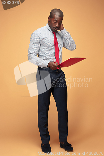 Image of Attractive standing Afro-American businessman writing notes