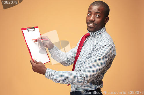 Image of Attractive standing Afro-American businessman writing notes