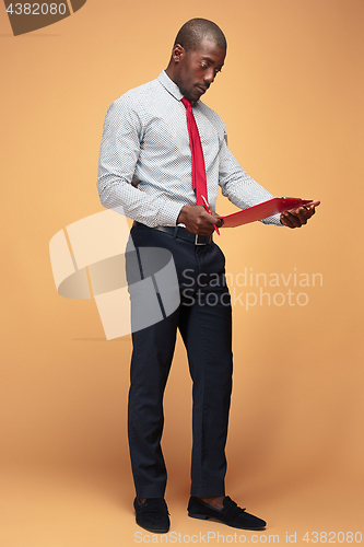 Image of Attractive standing Afro-American businessman writing notes