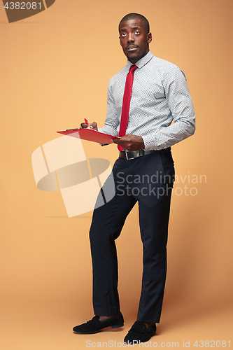 Image of Attractive standing Afro-American businessman writing notes