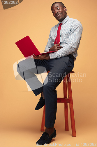 Image of Handsome Afro American man sitting and using a laptop