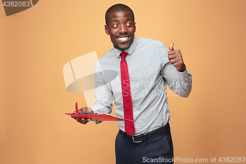 Image of Attractive standing Afro-American businessman writing notes