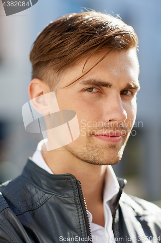 Image of portrait of young man in leather jacket outdoors