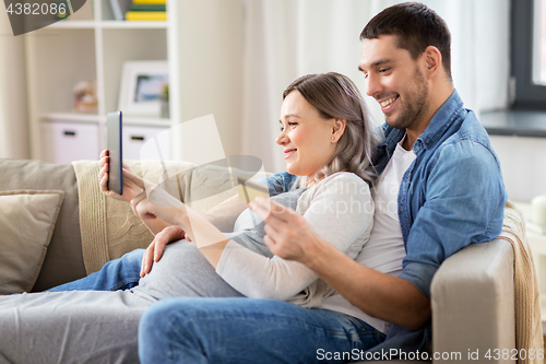 Image of man and pregnant wife shopping online at home