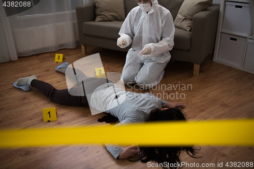 Image of criminalist collecting evidence at crime scene