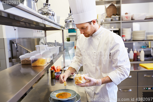 Image of happy male chef cooking food at restaurant kitchen