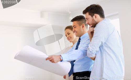 Image of realtor showing blueprint of new home to couple