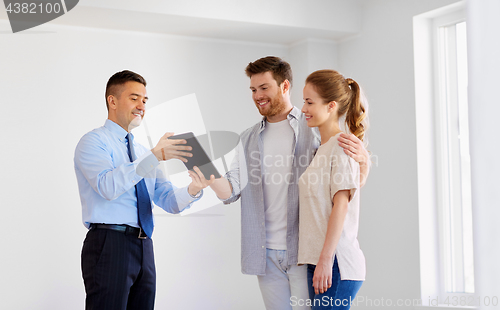 Image of couple and realtor with tablet pc at new home