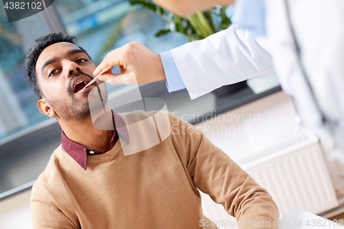 Image of doctor examining patient throat at clinic