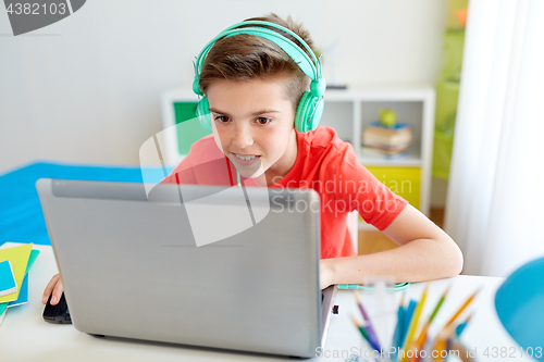 Image of boy in headphones playing video game on laptop