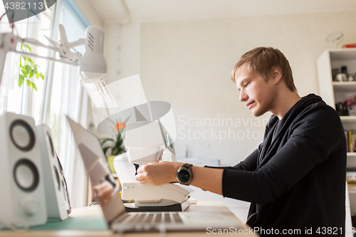 Image of fashion designer with sewing machine at studio