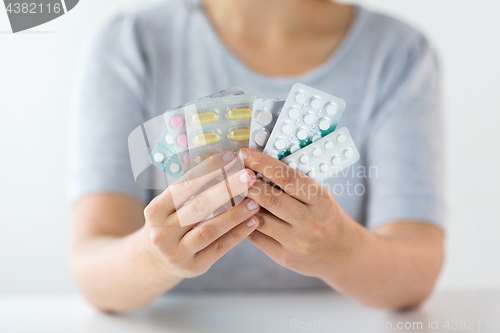 Image of woman hands holding packs of pills