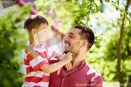 Image of happy father and son at summer garden
