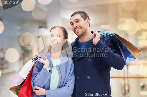 Image of happy young couple with shopping bags in mall