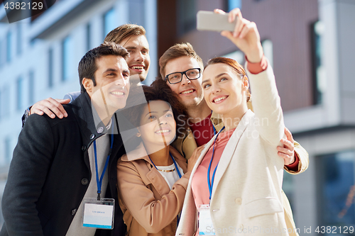 Image of business team with conference badges taking selfie