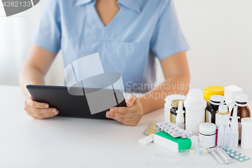 Image of nurse or doctor with medicines and tablet pc