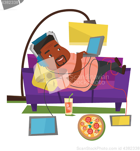 Image of Man lying on sofa with many gadgets.