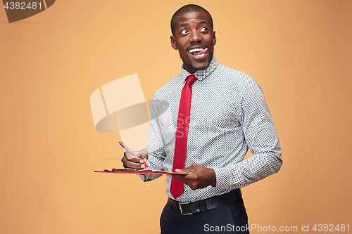 Image of Attractive standing Afro-American businessman writing notes