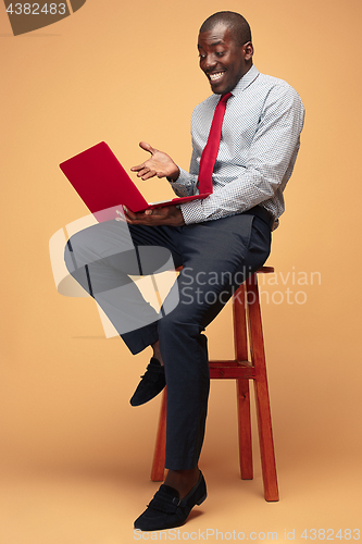 Image of Handsome Afro American man sitting and using a laptop