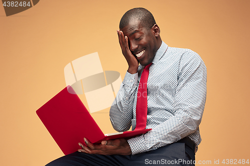 Image of Handsome Afro American man sitting and using a laptop