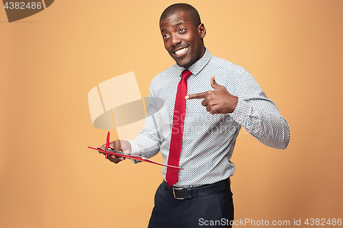 Image of Attractive standing Afro-American businessman writing notes