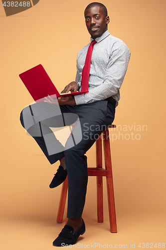 Image of Handsome Afro American man sitting and using a laptop