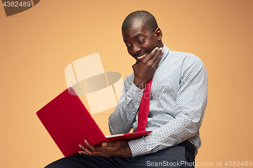 Image of Handsome Afro American man sitting and using a laptop