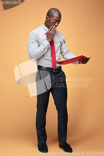 Image of Attractive standing Afro-American businessman writing notes