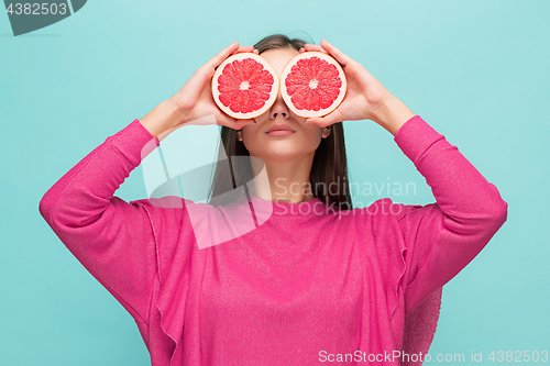 Image of Pretty woman with delicious grapefruit in her arms.