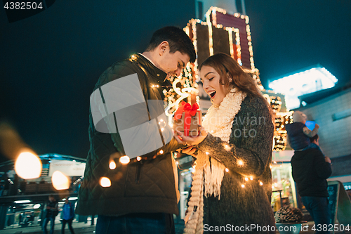 Image of romantic surprise for Christmas, woman receives a gift from her boyfriend