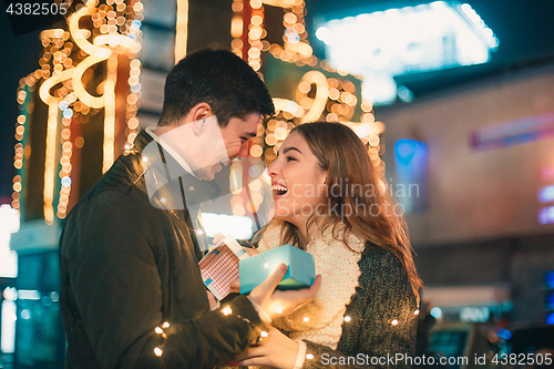 Image of romantic surprise for Christmas, woman receives a gift from her boyfriend