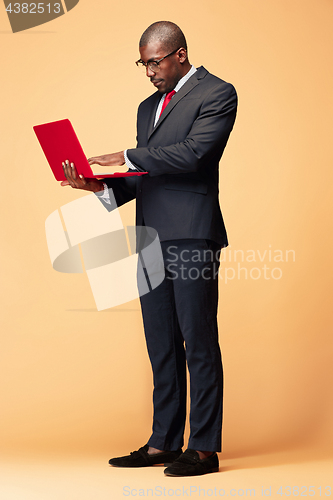 Image of Handsome Afro American man standing with a laptop