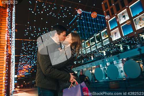 Image of The happy couple with shopping bags enjoying night at city background