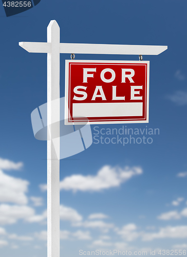 Image of Right Facing For Sale Real Estate Sign on a Blue Sky with Clouds