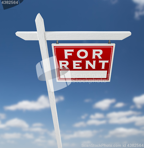 Image of Right Facing For Rent Real Estate Sign on a Blue Sky with Clouds