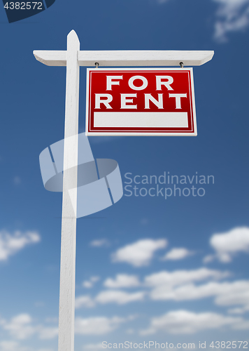 Image of Right Facing For Rent Real Estate Sign on a Blue Sky with Clouds