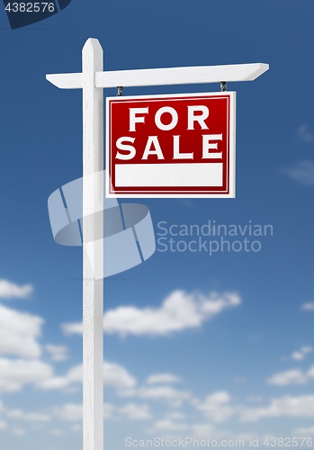 Image of Right Facing For Sale Real Estate Sign on a Blue Sky with Clouds