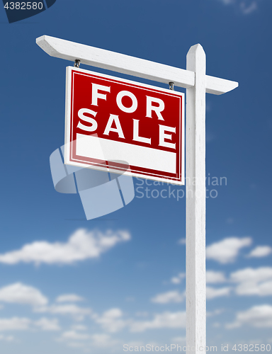 Image of Left Facing For Sale Real Estate Sign on a Blue Sky with Clouds.