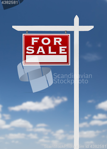 Image of Left Facing For Sale Real Estate Sign on a Blue Sky with Clouds.