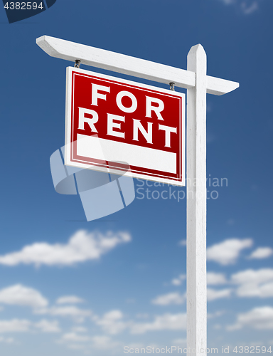 Image of Left Facing For Rent Real Estate Sign on a Blue Sky with Clouds.