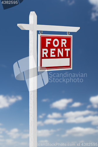 Image of Right Facing For Rent Real Estate Sign on a Blue Sky with Clouds