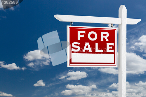 Image of Left Facing For Sale Real Estate Sign Over Blue Sky and Clouds W