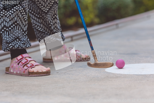 Image of Happy little girl  playing mini golf.