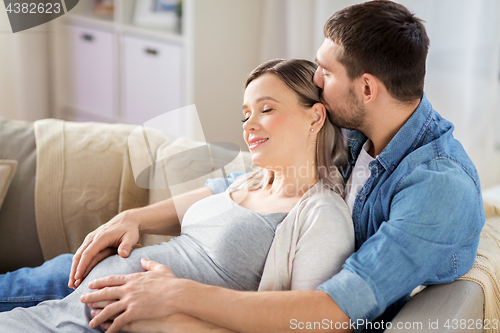 Image of man hugging pregnant woman at home