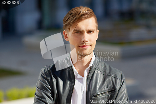 Image of portrait of young man in leather jacket outdoors