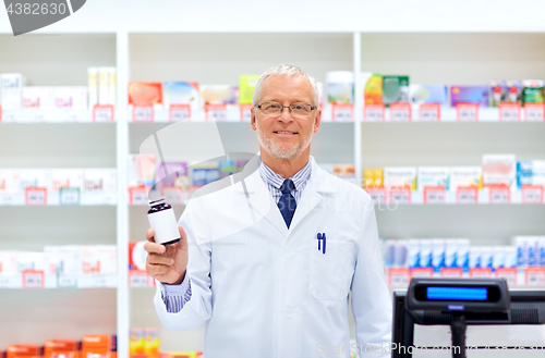 Image of senior apothecary with drug at pharmacy