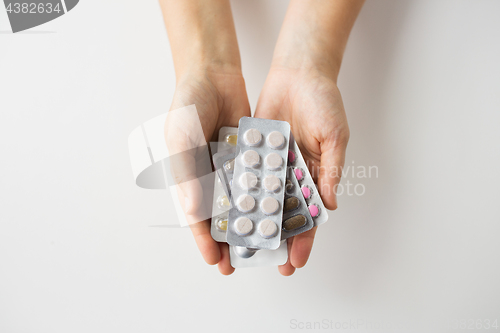 Image of woman hands holding packs of pills