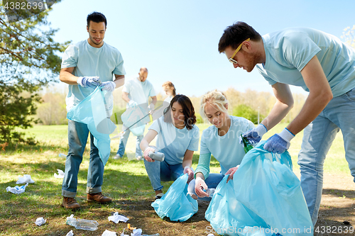 Image of volunteers with garbage bags cleaning park area